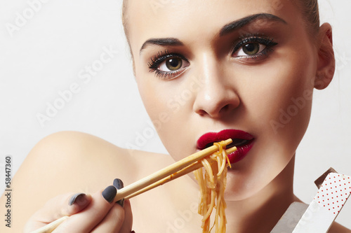 Photo: Beautiful woman eating chinese food. wok. noodles Beautiful woman eating chinese food. wok. noodles