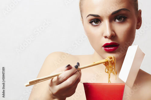 Photo: beautiful woman are eating noodles.red lips.Chinese sticks beautiful woman are eating noodles.red lips.Chinese sticks