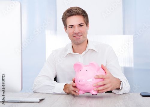 Photo: Businessman Holding Piggybank Businessman Holding Piggybank