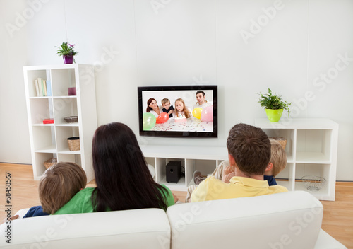 Photo: Young family watching TV Young family watching TV