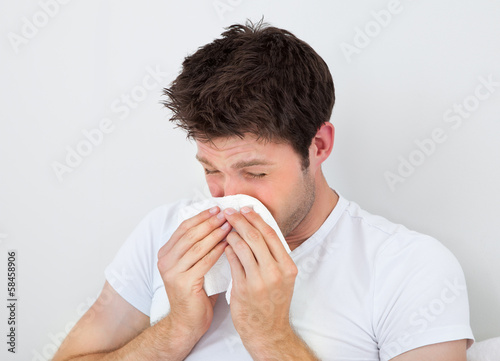 Photo: Man Sneezing Into A Tissue Man Sneezing Into A Tissue