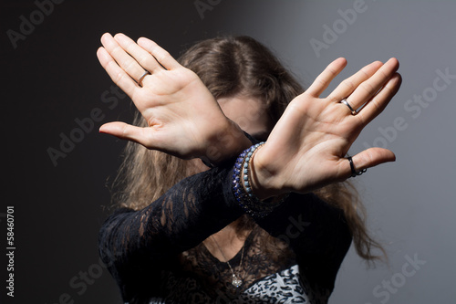Photo: Out of focus woman with her hands signaling to stop isolated Out of focus woman with her hands signaling to stop isolated