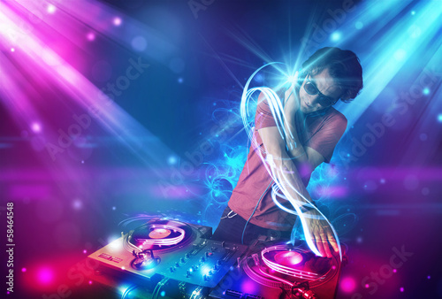 Photo: Energetic Dj mixing music with powerful light effects Energetic Dj mixing music with powerful light effects