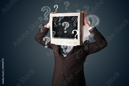 Photo: Businessman with a computer monitor head and question marks Businessman with a computer monitor head and question marks