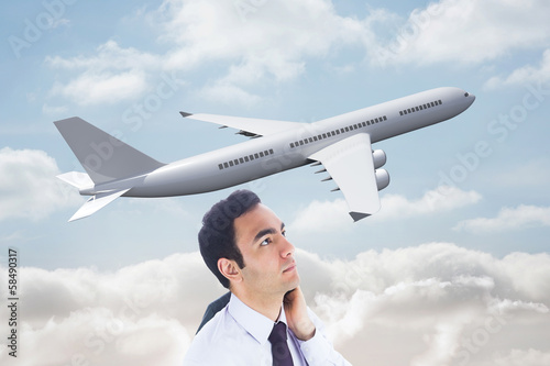 Photo: Composite image of unsmiling businessman standing Composite image of unsmiling businessman standing