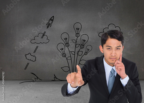 Photo: Composite image of thoughtful asian businessman pointing Composite image of thoughtful asian businessman pointing