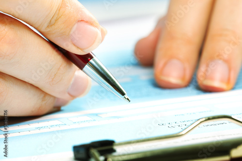 Photo: Business woman filling document. Business woman filling document.