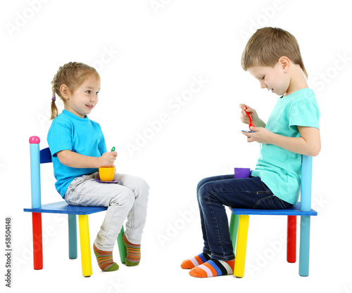 Photo: Little children playing with colorful tableware isolated Little children playing with colorful tableware isolated