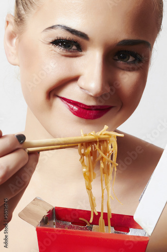 Photo: happy beautiful woman eating chinese food. red lips.smile happy beautiful woman eating chinese food. red lips.smile