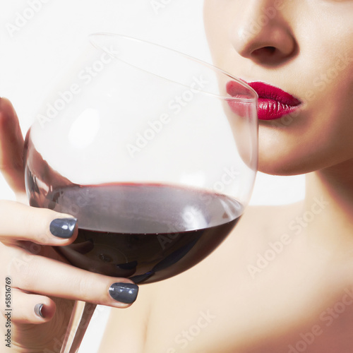 Photo: Beautiful woman drinking red wine.wineglass.red lips Beautiful woman drinking red wine.wineglass.red lips