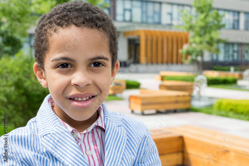 Photo: Little mulatto boy in a striped jacket in the park Little mulatto boy in a striped jacket in the park