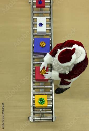Photo: santa clause working at production line in presents factor santa clause working at production line in presents factor