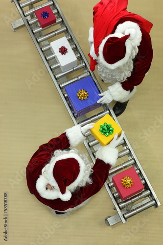 Photo: santa clauses working at conveyor belt in Christmas factory santa clauses working at conveyor belt in Christmas factory