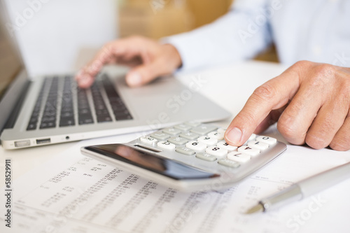 Photo: Man doing his accounting, financial adviser working Man doing his accounting, financial adviser working