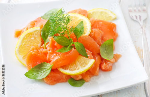 Photo: fresh salmon with lemon on the white plate fresh salmon with lemon on the white plate