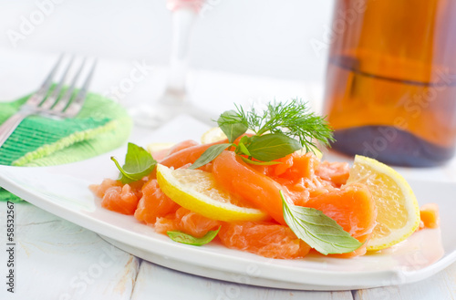 Photo: fresh salmon with lemon on the white plate fresh salmon with lemon on the white plate