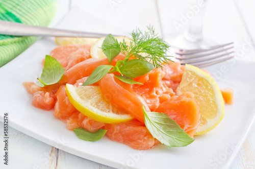 Photo: fresh salmon with lemon on the white plate fresh salmon with lemon on the white plate