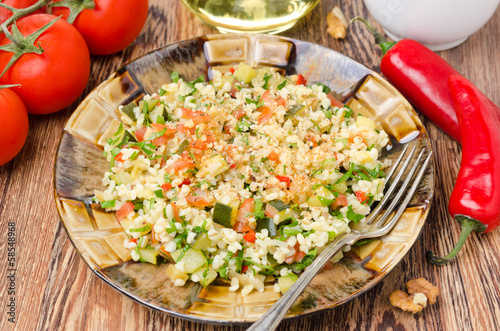 Photo: salad with bulgur, zucchini, tomatoes, parsley on the plate salad with bulgur, zucchini, tomatoes, parsley on the plate