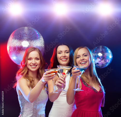 Photo: three smiling women with cocktails and disco ball three smiling women with cocktails and disco ball