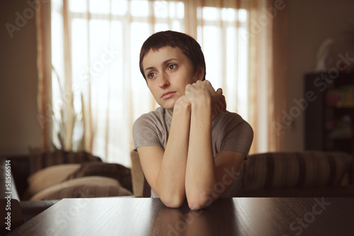 Photo: Beautiful cute woman sitting at a table Beautiful cute woman sitting at a table