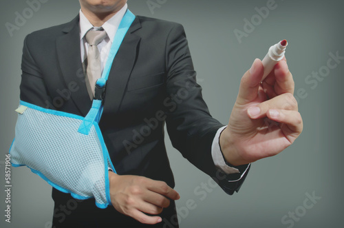 Photo: young businessman with broken hand wearing an arm brace, series young businessman with broken hand wearing an arm brace, series