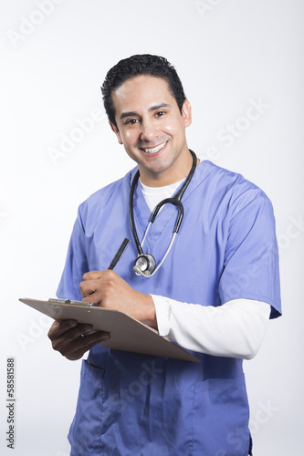 Photo: Smiling male nurse writing on clipboard Smiling male nurse writing on clipboard