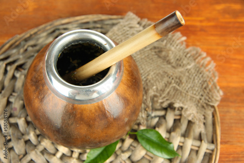Photo: Calabash and bombilla with yerba mate on wooden background Calabash and bombilla with yerba mate on wooden background