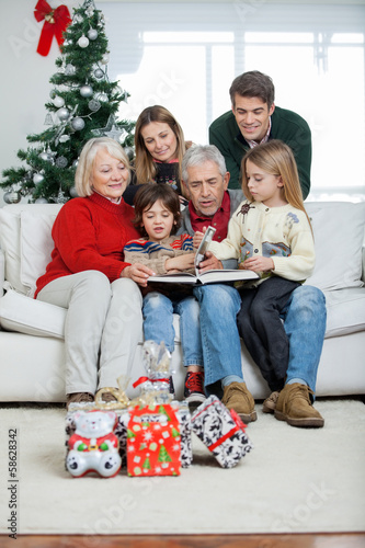 Photo: Family Looking At Book In House Family Looking At Book In House