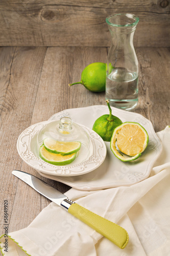 Photo: Lemon on plate and water on wooden table Lemon on plate and water on wooden table