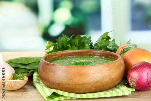 Photo: Tasty spinach soup, on wooden table Tasty spinach soup, on wooden table