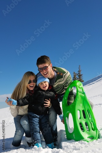 Photo: family having fun on fresh snow at winter vacation family having fun on fresh snow at winter vacation