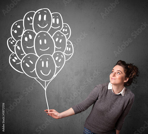Photo: Woman holding a bunch of smiling balloons Woman holding a bunch of smiling balloons