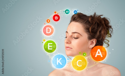 Photo: Pretty young girl with colorful vitamin icons and symbols Pretty young girl with colorful vitamin icons and symbols
