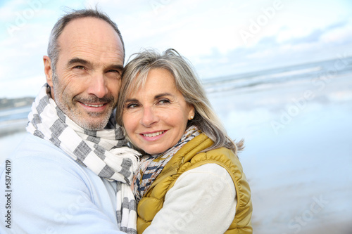 Photo: Portrait of loving senior couple at the beach Portrait of loving senior couple at the beach