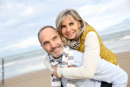 Photo: Senior man giving piggyback ride to wife Senior man giving piggyback ride to wife
