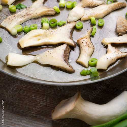 Photo: In Scheiben geschnittene Kräuterseitlinge braten in einer Pfanne In Scheiben geschnittene Kräuterseitlinge braten in einer Pfanne