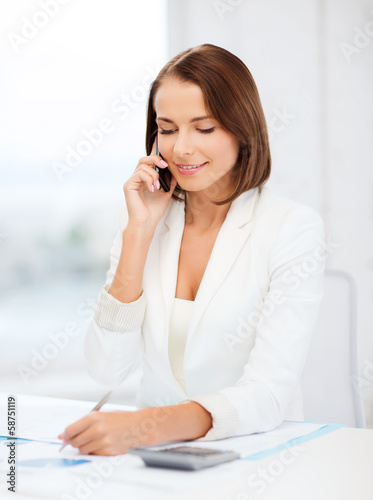 Photo: woman with papers, calculator and smartphone woman with papers, calculator and smartphone