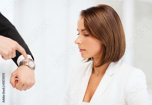 Photo: boss showing time to stressed businesswoman boss showing time to stressed businesswoman