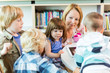 Teacher With Students Using Digital Tablet In Library Teacher With Students Using Digital Tablet In Library
