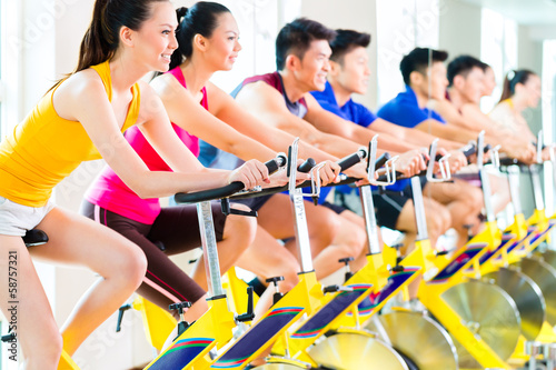 Photo: Asian people in spinning bike training at fitness gym Asian people in spinning bike training at fitness gym