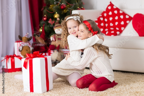 Photo: two adorable curly girls playing with gift box two adorable curly girls playing with gift box