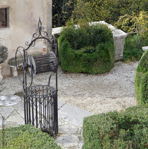 Photo: ancient well in the cured Italian-style garden of a villa ancient well in the cured Italian-style garden of a villa