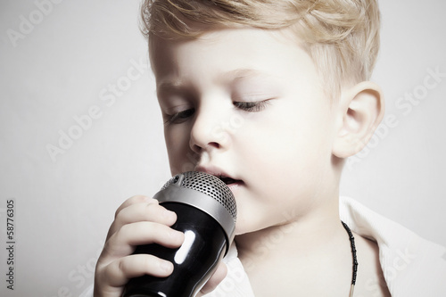 Photo: little boy singing in microphone.child in karaoke.music little boy singing in microphone.child in karaoke.music