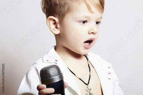Photo: little boy singing in microphone.child in karaoke.rock music little boy singing in microphone.child in karaoke.rock music