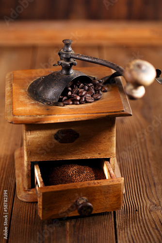 Photo: Old coffee mill with coffee beans, close-up Old coffee mill with coffee beans, close-up
