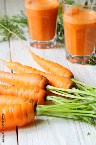 Photo: carrot on the table and two glasses of juice carrot on the table and two glasses of juice