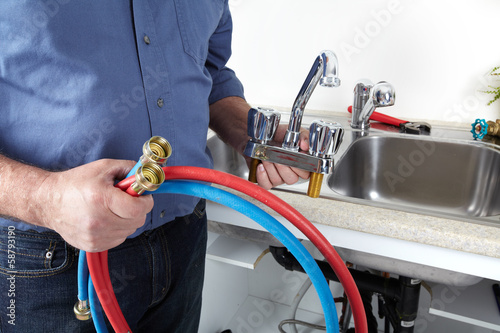 Photo: Hands of Plumber with a wrench. Hands of Plumber with a wrench.