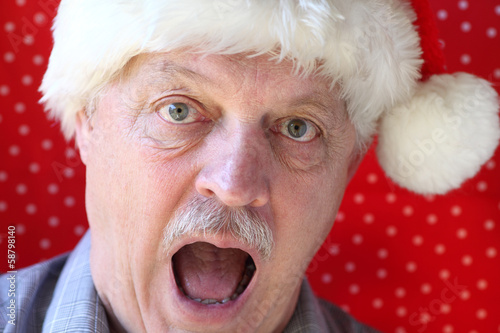 Photo: Santa hat on man looking alarmed Santa hat on man looking alarmed