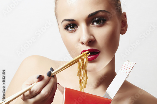 Photo: beautiful woman are eating noodles.red lips.Chinese sticks. beautiful woman are eating noodles.red lips.Chinese sticks.