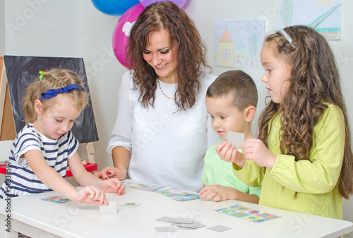 Photo: Teacher plays with children in kindergarten. Teacher plays with children in kindergarten.